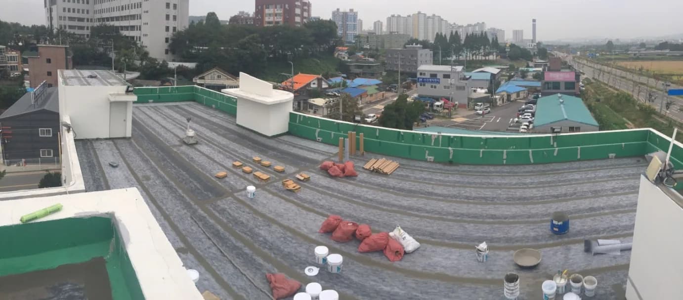 대면적 산업체 옥상에 3중 복합시트를 포설하는 시공 현장